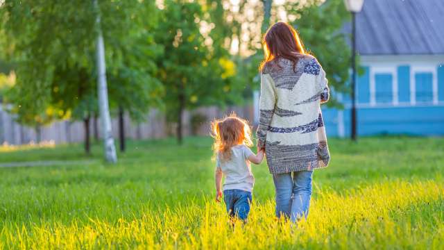 Mother and daughter holding hands and walking