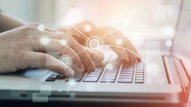 Hands typing at a laptop