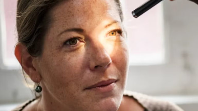 Patient having her eyes checked by ophthalmologist using a light