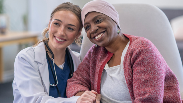 A smiling patient and healthcare provider sitting together.