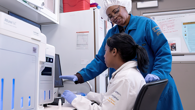 Two people using the Flow cytometry equipment in the UCLA Health Flow Cytometry Shared Resource laboratory, used for advanced cell analysis.
