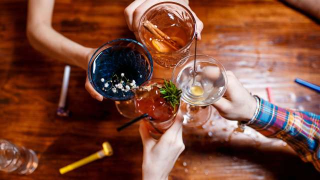 People holding up glasses of alcohol in celebration.
