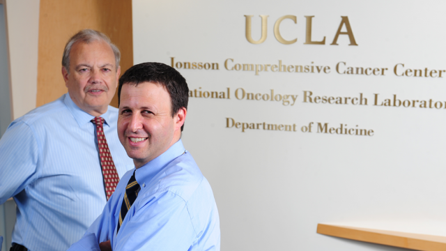 UCLA cancer researchers Dr. Dennis Slamon and Dr. Richard Finn, wearing light blue button up shirts and burgundy ties.
