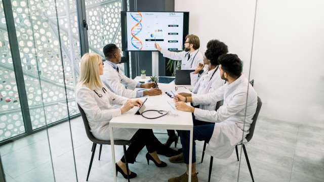 Doctors discussing a presentation in hospital conference room