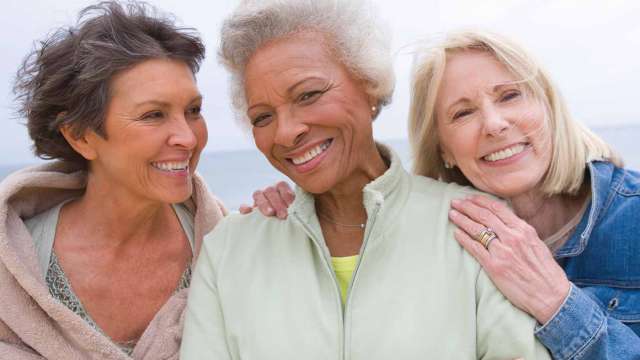 Three woman huddled together and smiling
