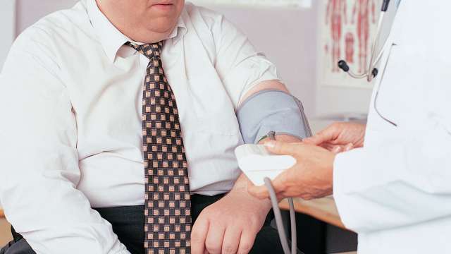 Doctor taking blood pressure overweight man