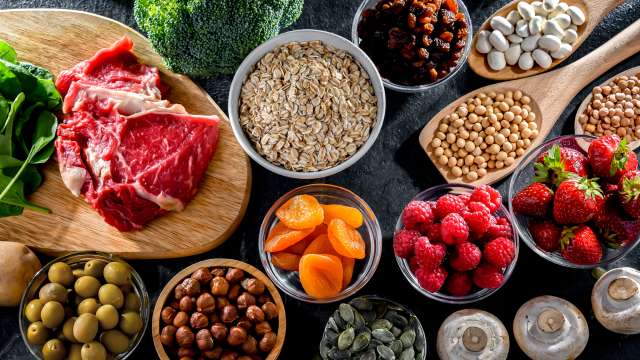 A table with fruit, nuts, vegetables and meat.