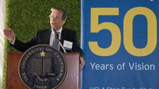 Dr. Mondino speaking at a podium during the reopening of the Jules Stein building