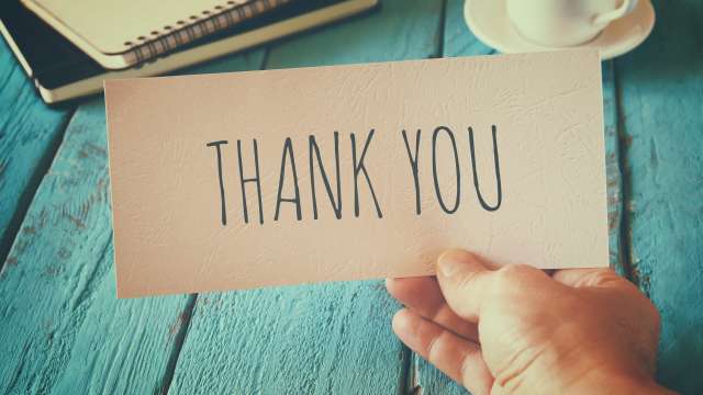 Hand holding a Thank You note
