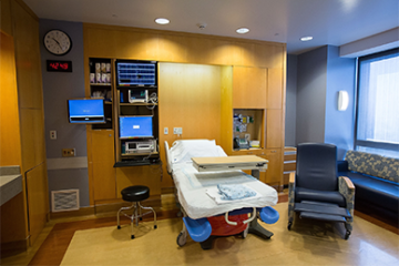 Birthing Suite - Used for vaginal deliveries. A patient's bed, monitors, medical equipment and a big window.