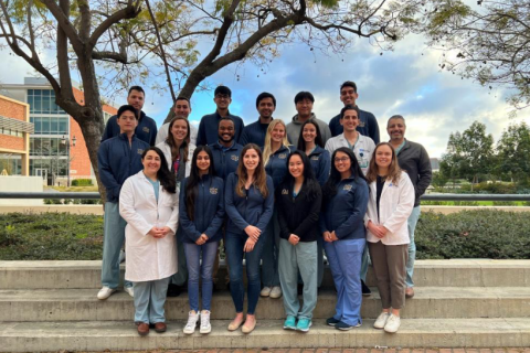 CORELAB team portrait outdoors, standing on steps near a tree.