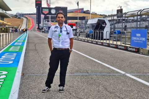 A man stands in pit lane on a Formula 1 racetrack.