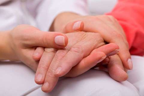 Holding elderly patient's hand