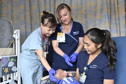 Clarissa Cabil, a NICU nurse at UCLA Mattel Children’s Hospital, provides care for a neonate alongside her mentor and a fellow nurse. 