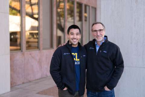 Justin Saco and Dr. Antoni Ribas in jackets standing outside a building