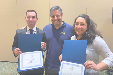 Two CORELAB Residents receiving award from a CORELAB member.
