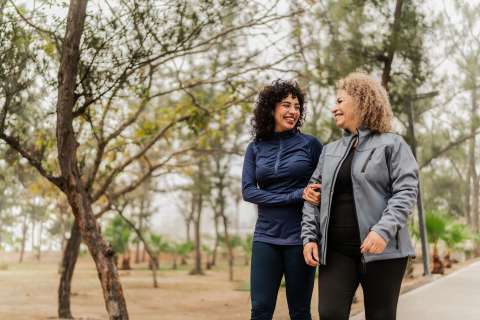 Two women walking in a park.