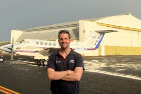 Dr. Matt Desmond in front of a medical transport airplane.
