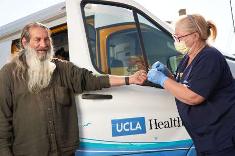 Man checked by nurse next to care van