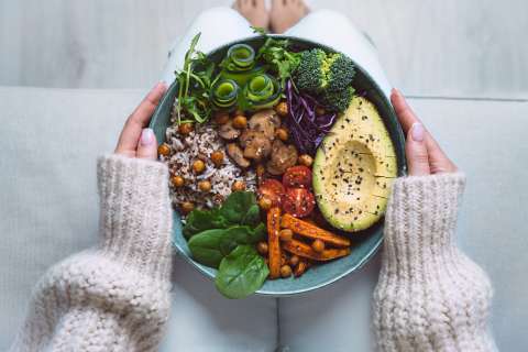 Woman holding dish of healthy foods