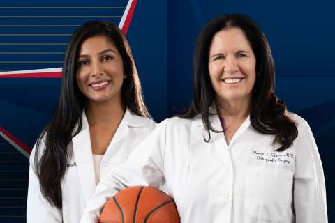 Two doctors pose with a basketball.