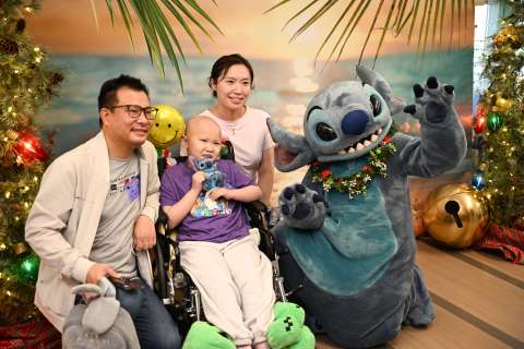 Disney character Stitch with a patient and her family.