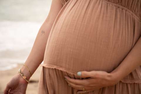 A pregnant mom shows the hummingbird tattoo on her right arm.