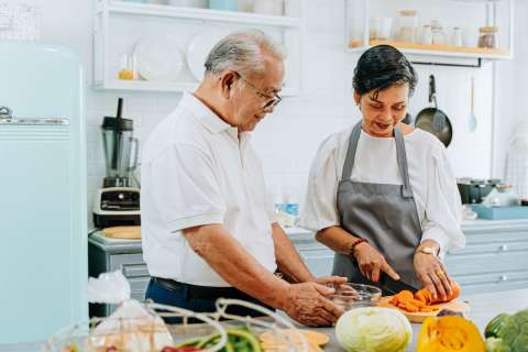 Husband and wife preparing a healthy meal.