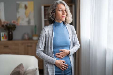 Older woman holding abdomen in pain