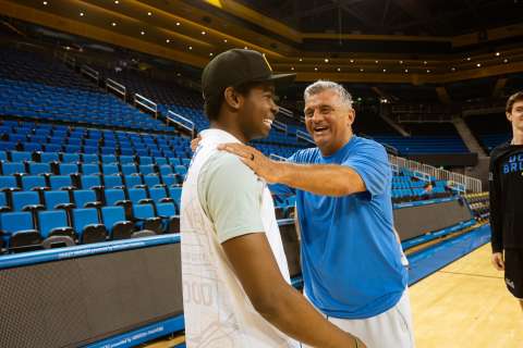 A patient and a volleyball coach greet each other on the court.