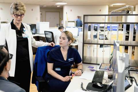 Coleen Wilson, a chief nursing officer, speaks with nursing staff in a hospital setting.