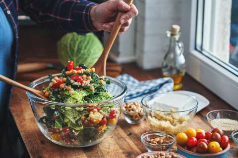 Person eating a salad bowl filled with veggies