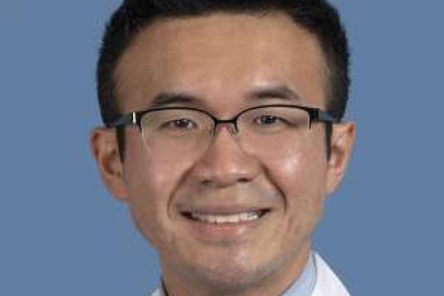 Medical professional in a white coat with a blue background.