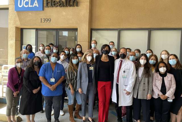 UCLA Health staff wearing masks gathered outside clinic entrance.