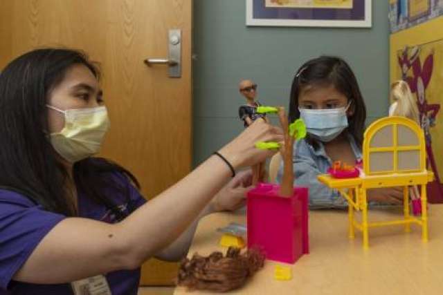 Child Life Specialist Millicent Ongaco plays with Layla Lopez, 5. 
