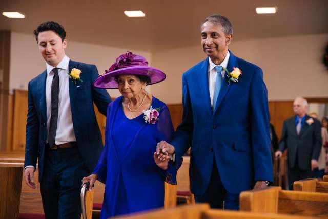 Teresa Rodrigues walks down the aisle of her church for her special 100th birthday mass service with her son and grandson. (Photo courtesy of Mitchell Maher)