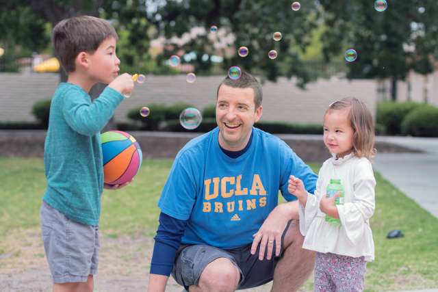 Carl Link blowing bubbles with his children