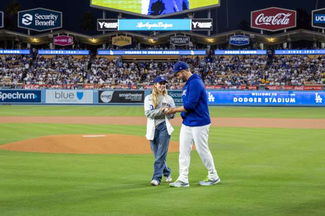 Josie Le Blanc and Clayton Kershaw walk near the pitcher's mound at Dodger Stadium