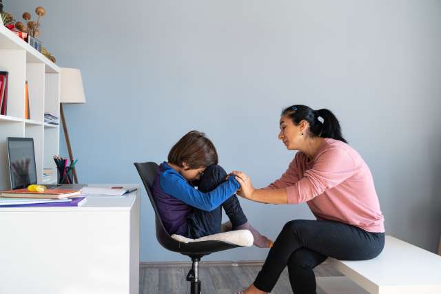 boy being comforted by woman
