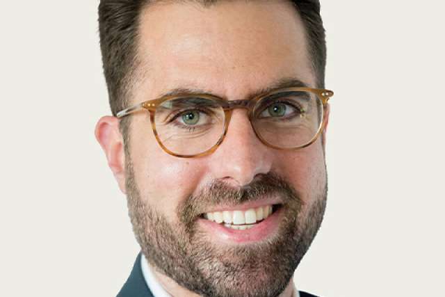 Professional headshot of a man wearing a suit and tie.