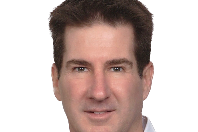 Portrait of person in navy sweater and white collared shirt