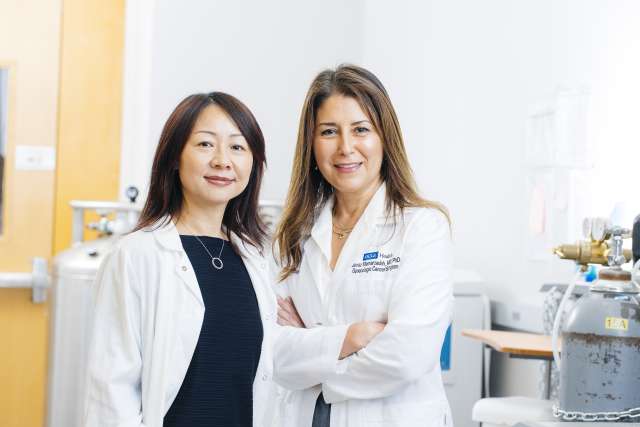 Drs. Lili Yang and Sanaz Memarzadeh smile beside one another in a UCLA lab.