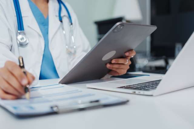 Physician reads off computer and tablet