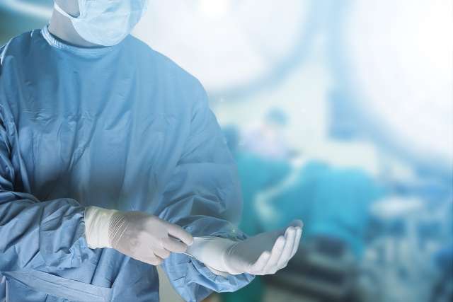 Surgeon putting on gloves