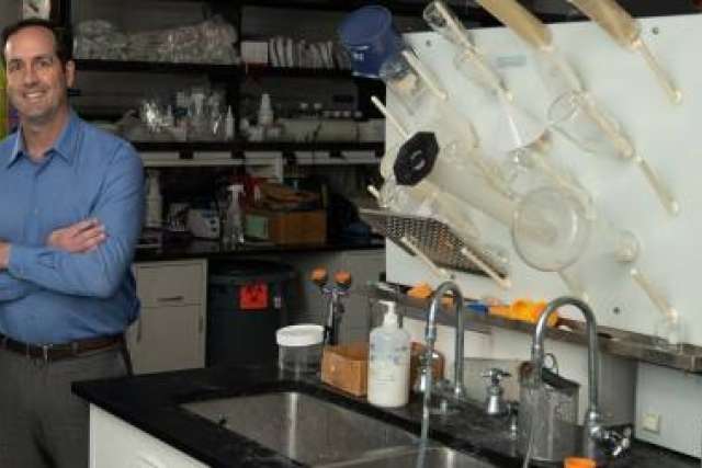 Dr. Robert Prins standing beside beaker washing station