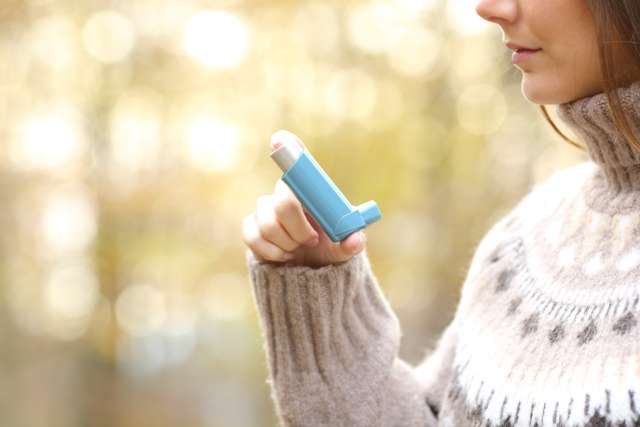 Woman using inhaler for respiratory disease