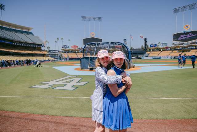 Susan Ford Dorsey and Elisabeth Okun embrace on the field at Dodger Stadium. 