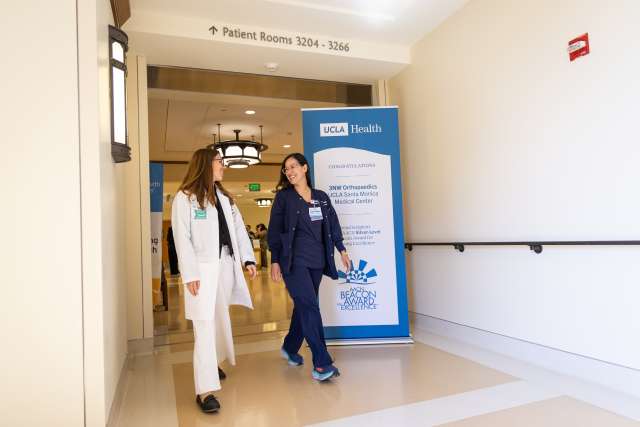 2 nursing leaders walk down hospital hallway