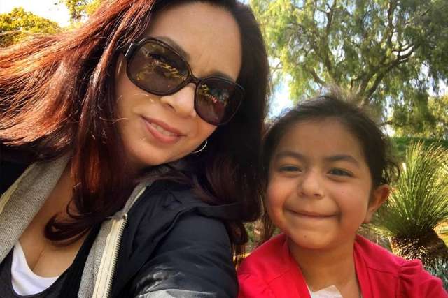 A smiling Giorgiana, wearing sunglasses, and her daughter Giuliana, are seen outdoors.