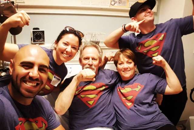Jim posing with friends and family all wearing Superman t-shirts
